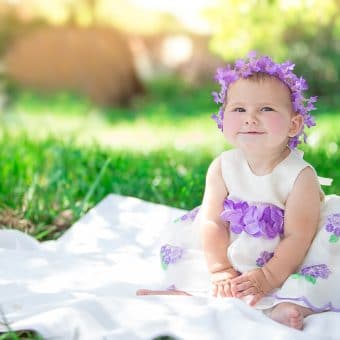 Baby in purple easter dress posing for an easter photography session with an orlando photographers