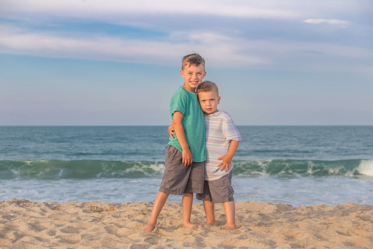 Brothers posing for a photo on the beach at sunset in Melbourne Beach FL