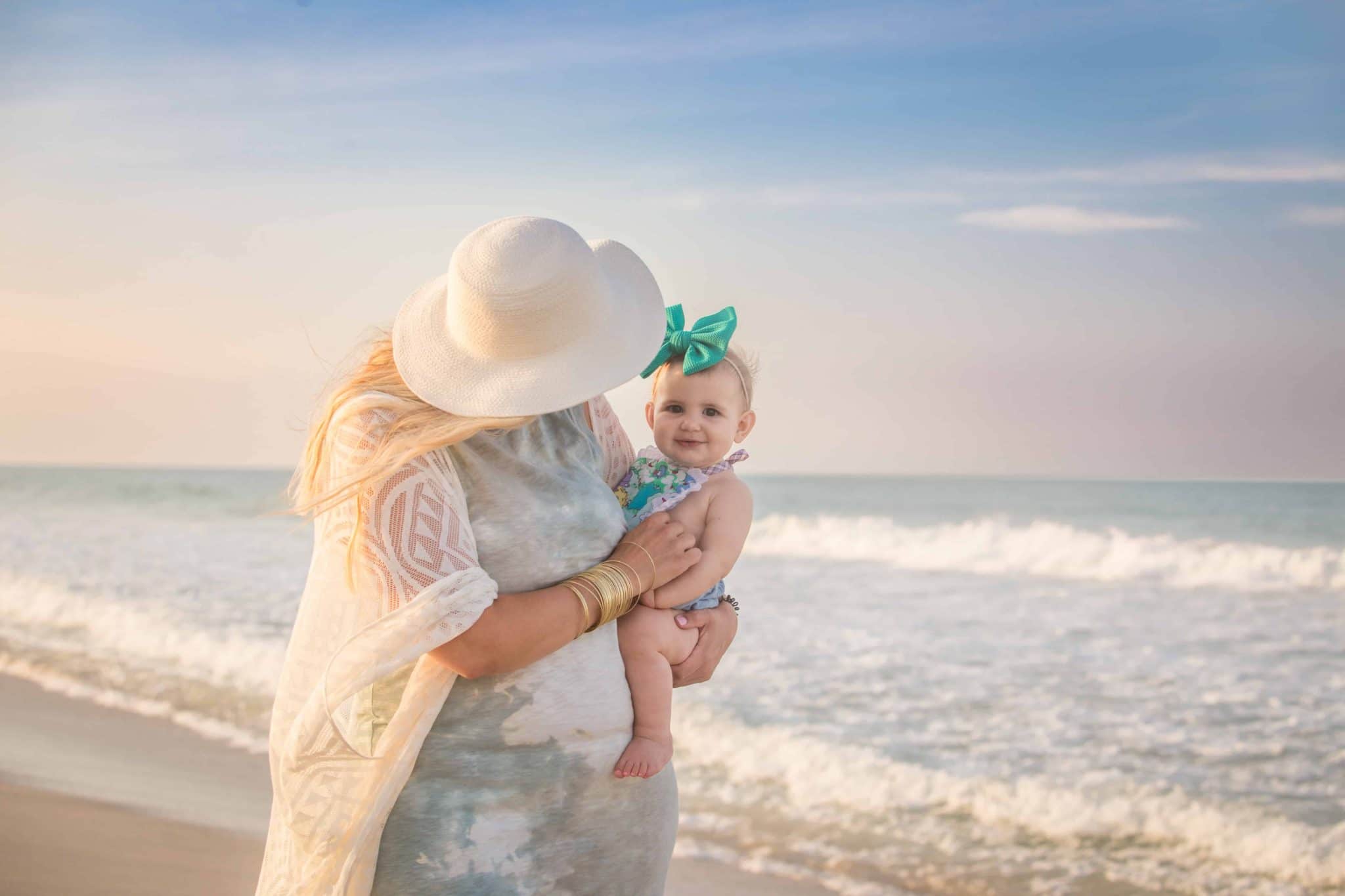 Mommy and baby on Melbourne beach in Florida at sunset with ocean in the background