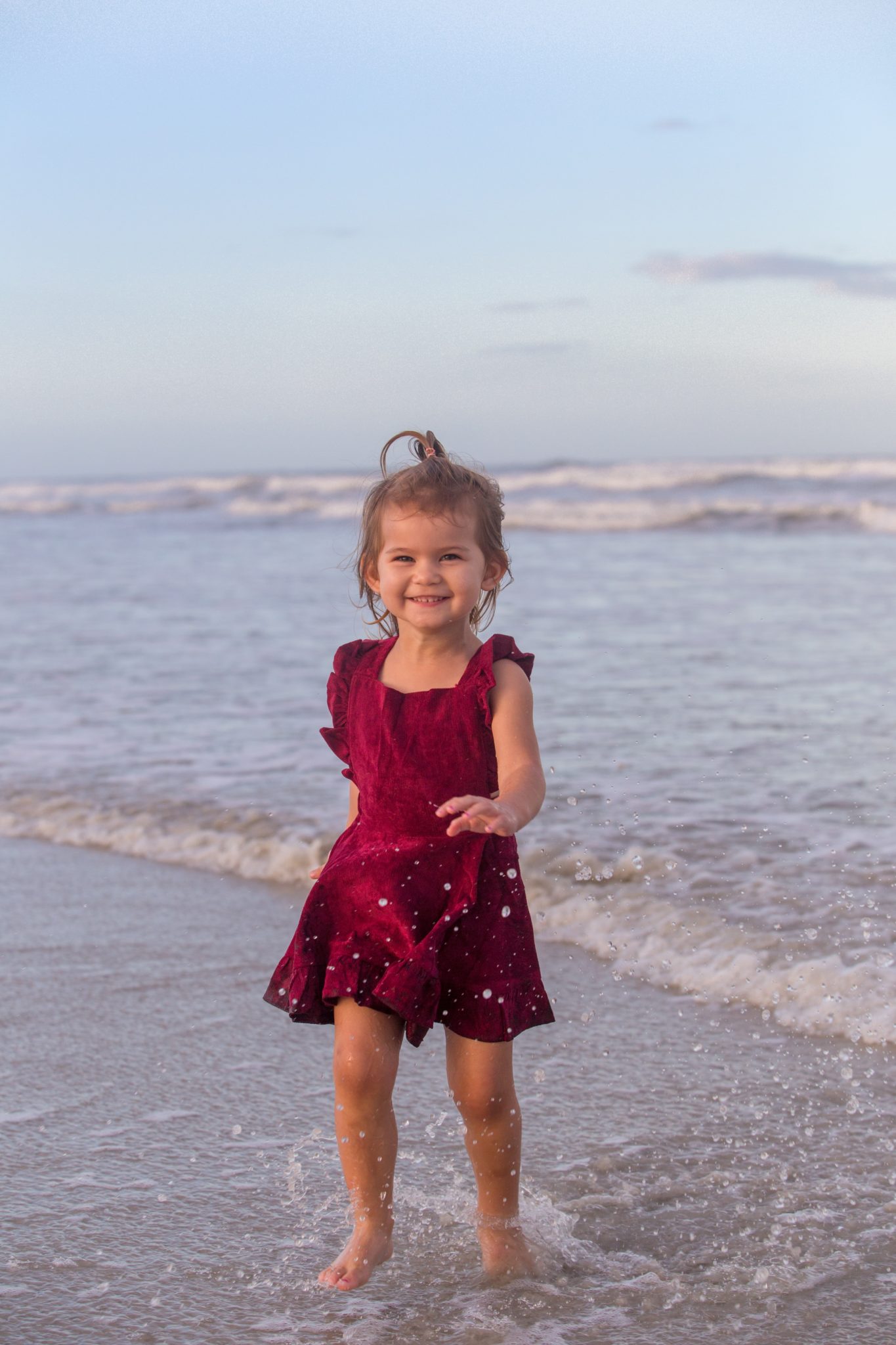 new smyrna beach portrait of little girl running in the shallow water at sunset by new smyrna beach photographer