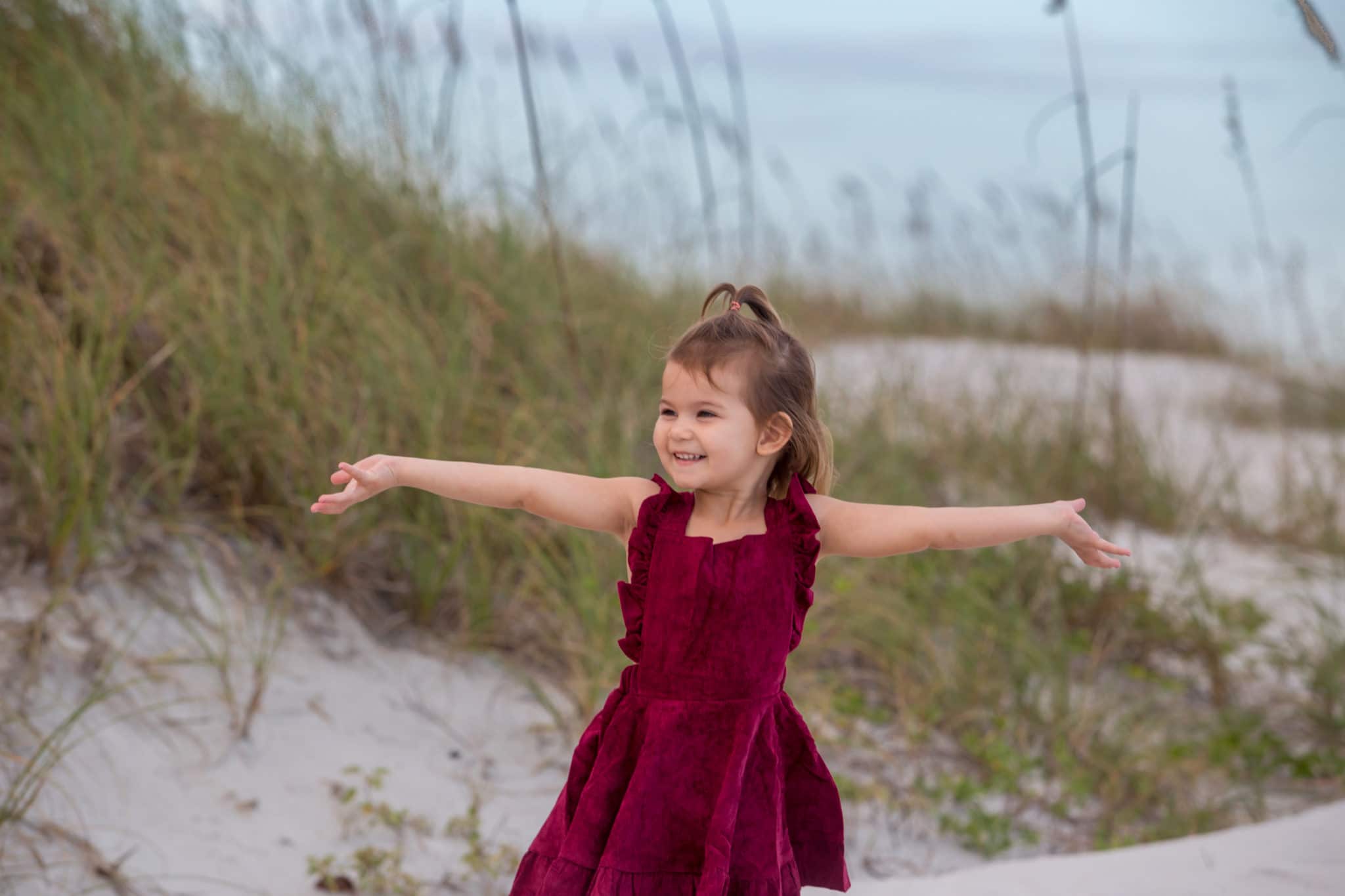 new smyrna beach family photography of little girl in front of sand dunes on the beach