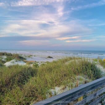 North Beach at sunset in New Smyrna Beach, FL taken from beach boardwalk, can view sand dunes, ocean and colorful sky