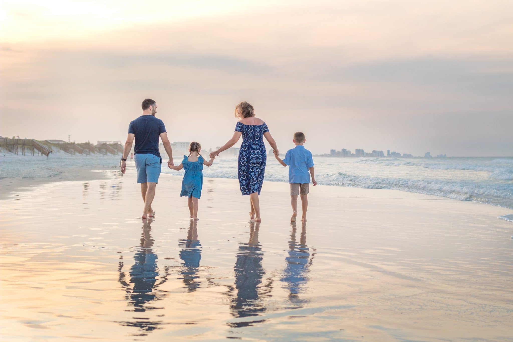 Daytona Beach family photography photography of family walking on the beach at sunset