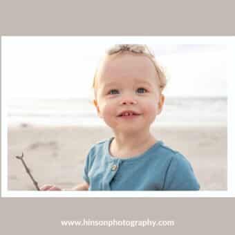 Photography of a little girl at the beach, holding a stick with a bright background
