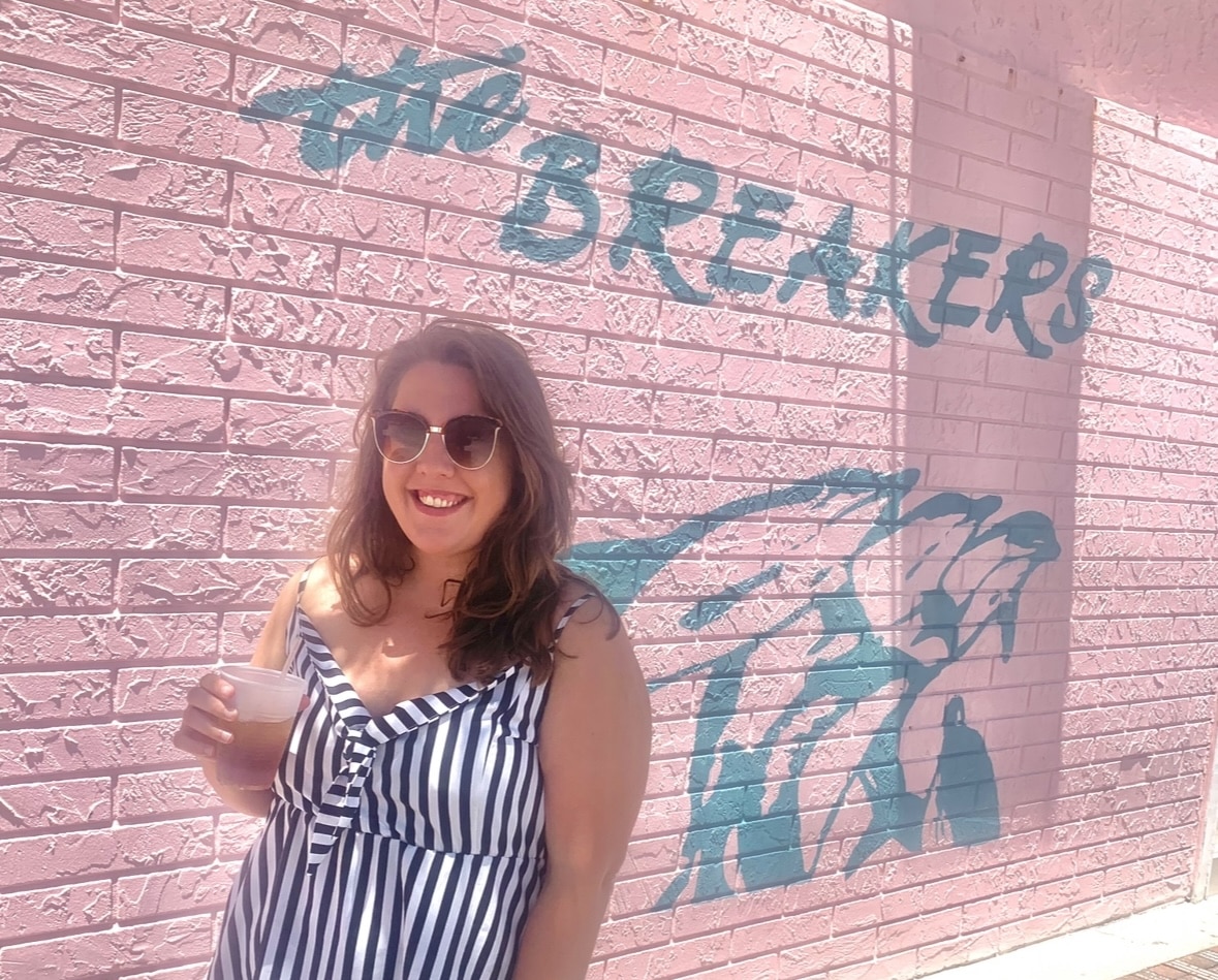 Me standing in front of breakers New Smyrna Beach oceanfront restaurant with a drink. The best burger New Smyrna Beach restaurants with outdoor seating