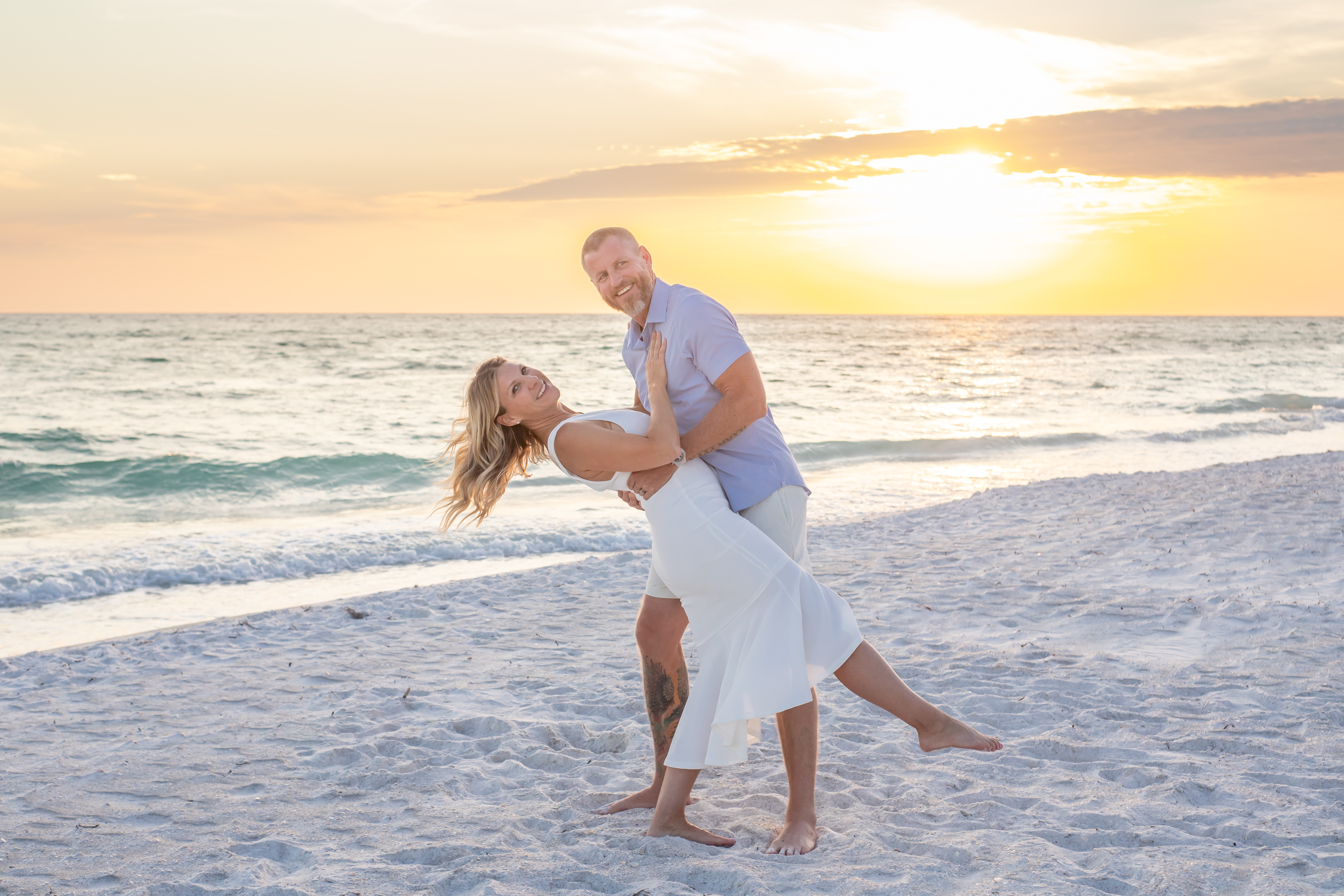 st. Pete Beach Photographer blog image for a post about date ideas in st. Pete Beach. couple doing a dip at sunset on the beach