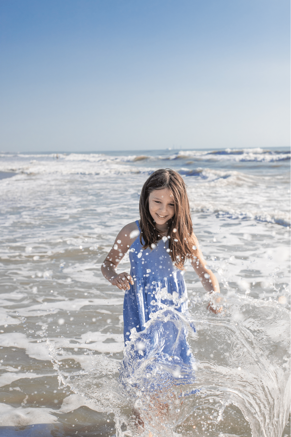 girl playing in the water at cocoa beach during a beach photoshoot by a cocoa beach family photographer