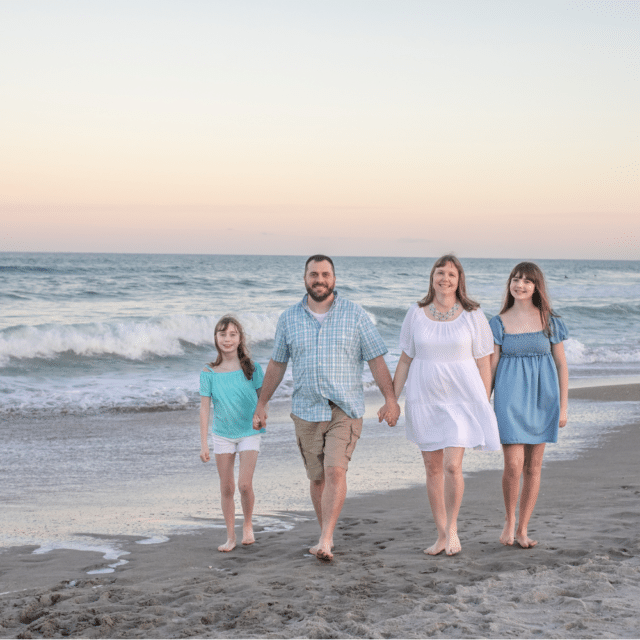 family of 4 walking along the beach for a photoshoot with a cocoa beach family photographer